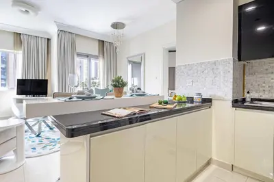 a kitchen with white cabinets and a counter top at Frank Porter - The Signature in Dubai