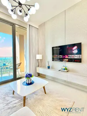 a living room with a tv and a table at Ultra Modern 1BR Forte Tower Near the BURJ and Mall in Dubai
