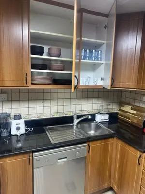 a kitchen with wooden cabinets and a sink at Sea View Luxe Room Marina Dubai in Dubai