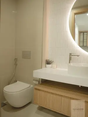 a bathroom with a toilet and a sink and a mirror at Elegant Haven by Meraki - New 1 Bed Garden View in Dubai