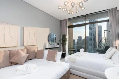 a bedroom with two beds and a large window at 2 Apt Combo Studio And 1BR Same Tower Canal View in Dubai