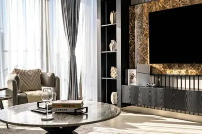 a living room with a table and a tv at Burj Khalifa Doorstep Stunning 2BR Apartment in Dubai