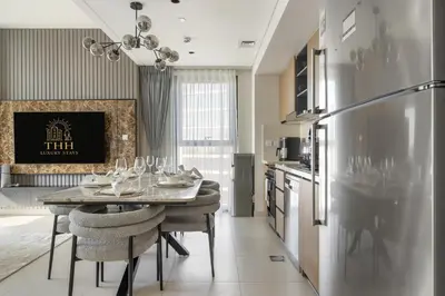 a kitchen with a table with chairs and a refrigerator at Burj Khalifa Doorstep Stunning 2BR Apartment in Dubai