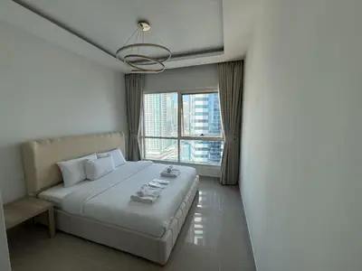 a bedroom with a bed and a large window at Aesthetic Feel with Lake View in Dubai