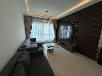 a living room with a couch and a television at Aesthetic Feel with Lake View in Dubai