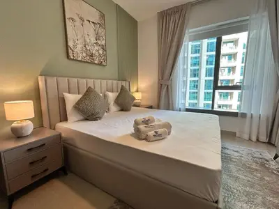 a bedroom with a large white bed with a window at Luxurious 1Bedroom Apt in 29 Boulevard - Downtown in Dubai