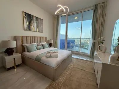 a bedroom with a bed and a large window at Luxury two bedroom at Gemz in Dubai