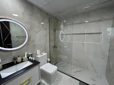a bathroom with a shower and a toilet and a sink at Luxury two bedroom at Gemz in Dubai