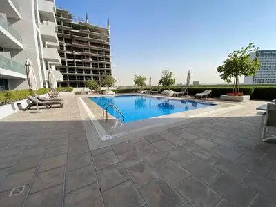 a swimming pool in the middle of a building at Bright and Stylish Studio - Azizi Aura in Dubai