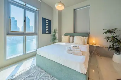 a bedroom with a large bed and a large window at Stylish Two-BHK Apartment - Iris Blue, Marsa Dubai in Dubai