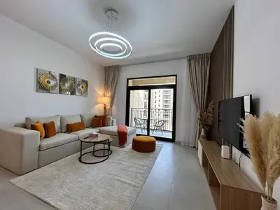 a living room with a couch and a tv at Comfortable one bed - Gym and Parking in Dubai