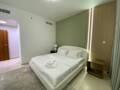 a bedroom with a bed with a teddy bear on it at Modern 2BR in Skycourt Tower A - Free Parking - Pool and Gym in Dubai