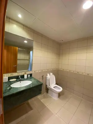 a bathroom with a toilet and a sink and a mirror at Modern 2BR in Skycourt Tower A - Free Parking - Pool and Gym in Dubai