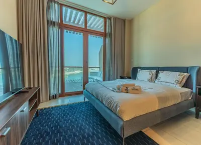 a bedroom with a bed and a large window at Stylish Studio Apt in Palm Views East PalmJumeirah in Dubai