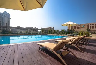 a swimming pool with lounge chairs and an umbrella at Stylish Studio Apt in Palm Views East PalmJumeirah in Dubai