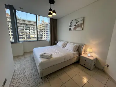 a bedroom with a bed and a large window at Luxury 2-Bedroom Apartment in DIFC in Dubai