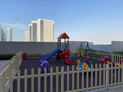a playground with a fence and a play set at Furnished studio apartment next to metro in Dubai