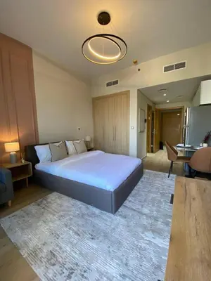 a bedroom with a large bed with a rug at Furnished studio apartment next to metro in Dubai