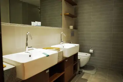 a bathroom with two sinks and a toilet at Luxurious 3 BR Apt in Park Gate Residences in Dubai