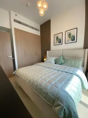 a bedroom with a large bed with a blue comforter at Cozy 1 Bedroom Apartment near Downtown in Dubai