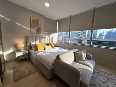 a bedroom with a bed and a couch in front of a window at Elegant Studio in Difc - Skyline Views, Pool, Gym in Dubai