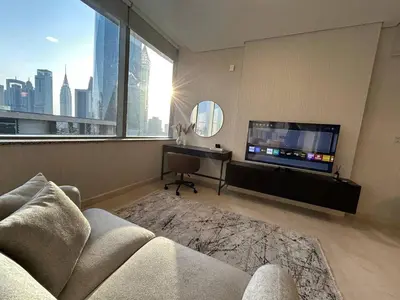 a living room with a couch and a flat screen tv at Elegant Studio in Difc - Skyline Views, Pool, Gym in Dubai