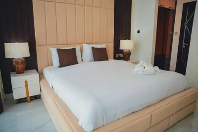 a bedroom with a large white bed with two lamps at Fully Furnished 2-Bedroom Apt in Gemz by Danube in Dubai
