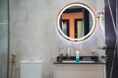 a bathroom with a mirror and a white toilet at Fully Furnished 2-Bedroom Apt in Gemz by Danube in Dubai
