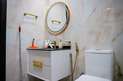 a bathroom with a white toilet and a mirror at Fully Furnished 2-Bedroom Apt in Gemz by Danube in Dubai