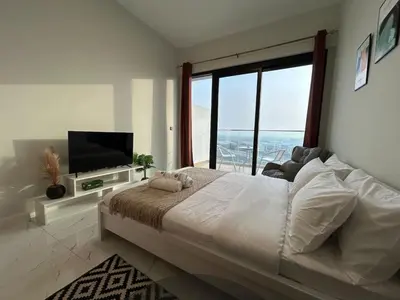 a bedroom with a large bed and a large window at Spacious 1BR - Alexis Tower 1 - Close to Metro in Dubai