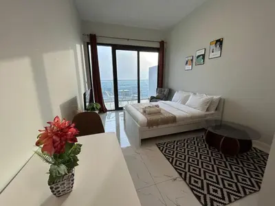 a living room with a bed and a table at Spacious 1BR - Alexis Tower 1 - Close to Metro in Dubai