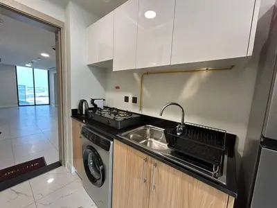 a kitchen with a sink and a washing machine at Spacious 1BR - Alexis Tower 1 - Close to Metro in Dubai