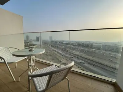 a balcony with a table and chairs and a view of a highway at Spacious 1BR - Alexis Tower 1 - Close to Metro in Dubai