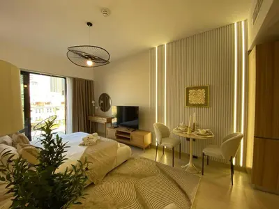 a bedroom with a bed and a table with chairs at Cozy Studio Apartment with Balcony in Dubai