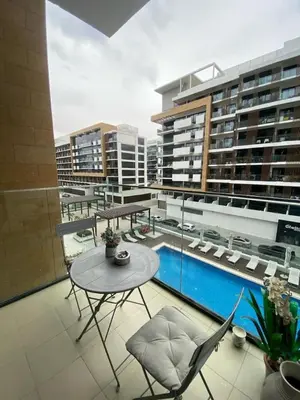 a balcony with a table and chairs on a building at Studio Apartment with Pool and Gym Access in Dubai
