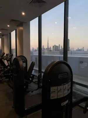 a gym with a view of a city from a building at Studio Apartment with Pool and Gym Access in Dubai