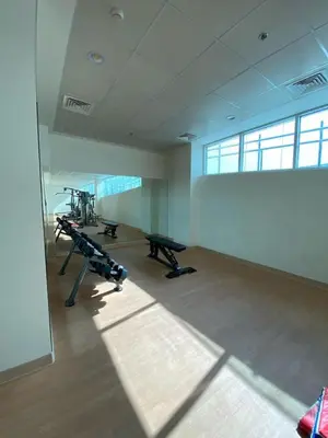 a gym with treadmills and machines in a room at Charming Studio Apartment in Jadaf in Dubai