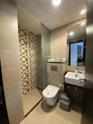 a bathroom with a toilet and a sink and a mirror at Charming Studio Apartment in Jadaf in Dubai