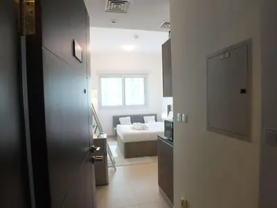 a room with a bedroom with a bed and a window at Charming Studio Apartment in Jadaf in Dubai