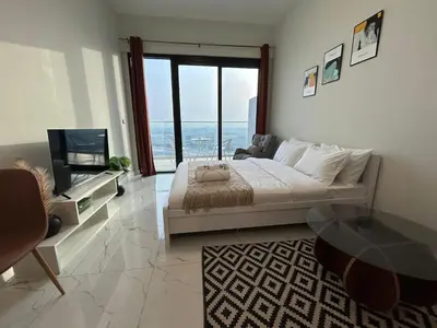 a large bedroom with a large bed and a television at Modern Studio Apt in Jabel Ali Near Metro in Dubai