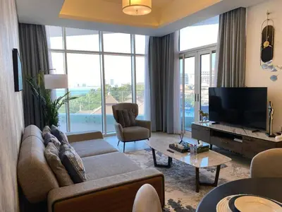 a living room with a couch and a television at Sea-facing 1BHK Apartment in Palm Jumeirah in Dubai