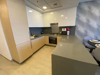 a kitchen with white cabinets and a counter top at Sea-facing 1BHK Apartment in Palm Jumeirah in Dubai