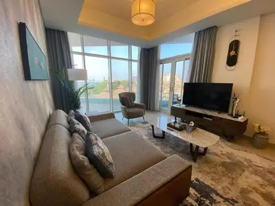 a living room with a couch and a television at Sea-facing 1BHK Apartment in Palm Jumeirah in Dubai