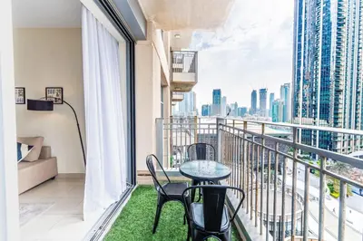a balcony with a table and chairs and a view of the city at Modern and Cozy One BHK Apt - Heart of Downtown Dubai in Dubai