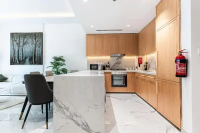 a kitchen with a marble counter top and wooden cabinets at Modern 1BR Apt in Azizi Riviera 51 - Pool and Gym in Dubai
