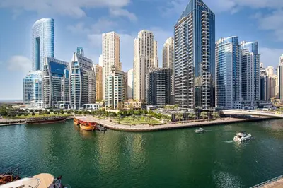 a city with tall buildings and a river with boats at Luxury 43rd Floor 2 Bedroom Apartment in Dubai Marina in Dubai