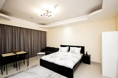 a bedroom with a bed and a couch and a table at Newly Furnished Studio at city tower building in Dubai