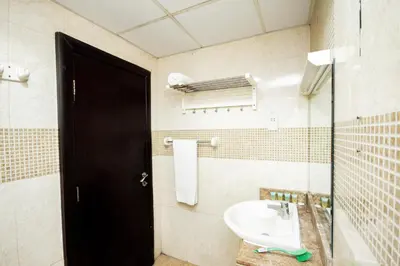 a bathroom with a sink and a black door at Newly Furnished Studio at city tower building in Dubai