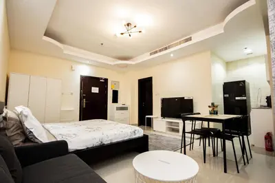 a living room with a bed and a table at Newly Furnished Studio at city tower building in Dubai