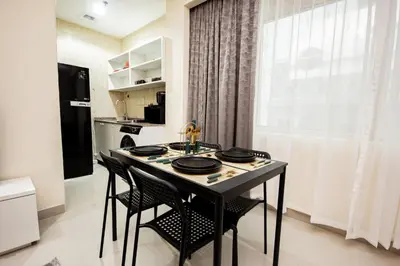 a kitchen with a table and chairs in a room at Newly Furnished Studio at city tower building in Dubai